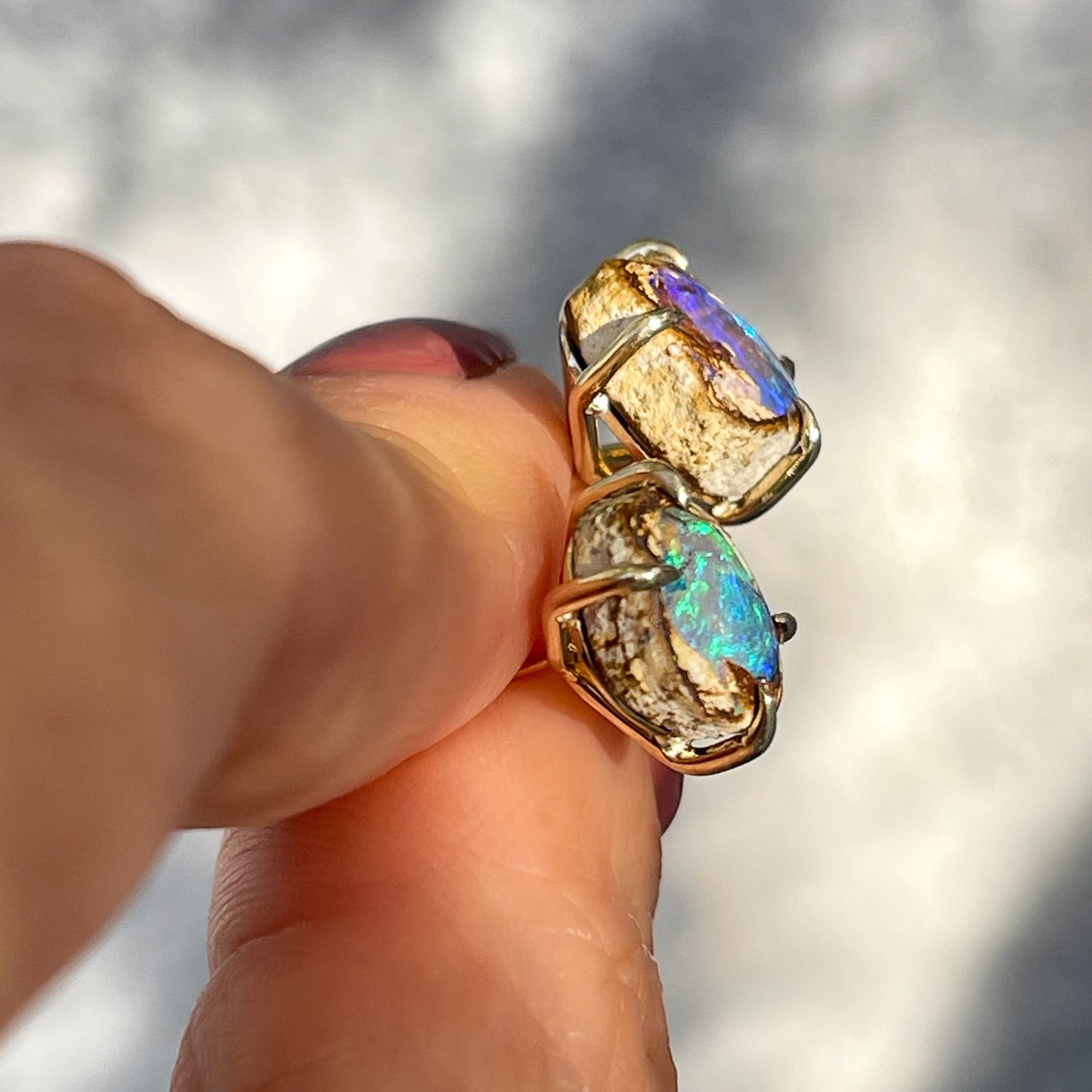 Side view of Australian Opal Earrings by NIXIN Jewelry. Mismatched earrings made with opals and gold.