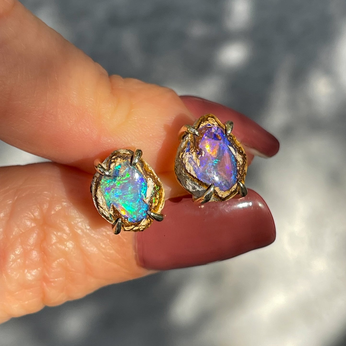 A pair of Australian Opal Earrings by NIXIN Jewelry. Gold opal earrings with purple and green opal.