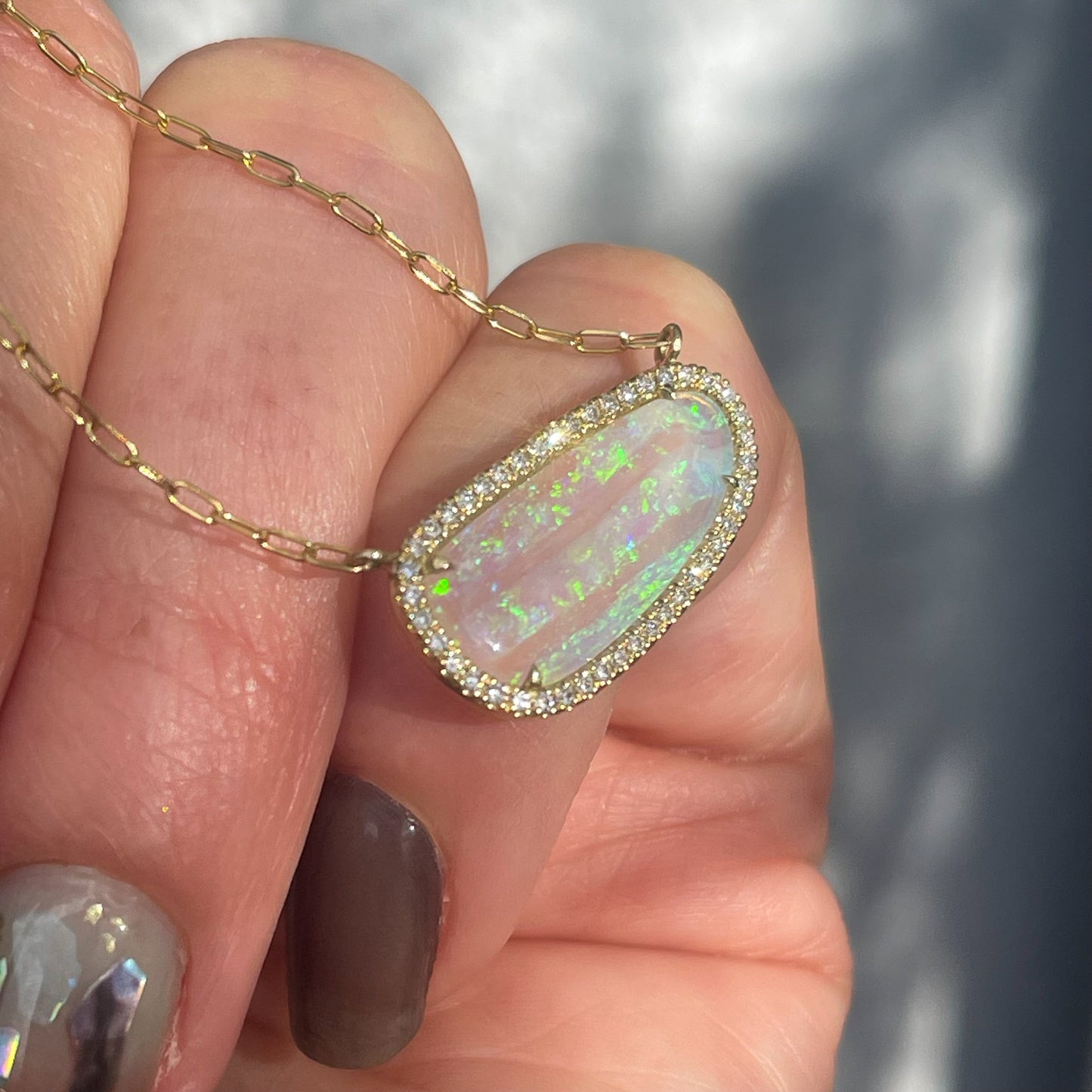 Side view of an Australian Opal Necklace by NIXIN Jewelry made in gold with opal and diamonds.