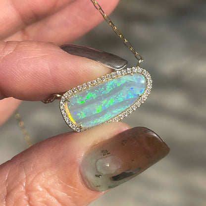 An Australian Opal Necklace by NIXIN Jewelry with an opal and diamond pendant set in gold.