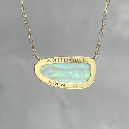 Back view of an Australian Opal Necklace by NIXIN Jewelry set in 14k gold showing location of its secret engraving.