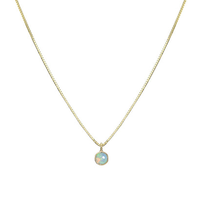 An Australian Opal Necklace by NIXIN Jewelry hangs in front of a white backdrop. The opal necklace pendant is made in 14k yellow gold with a Crystal Opal.