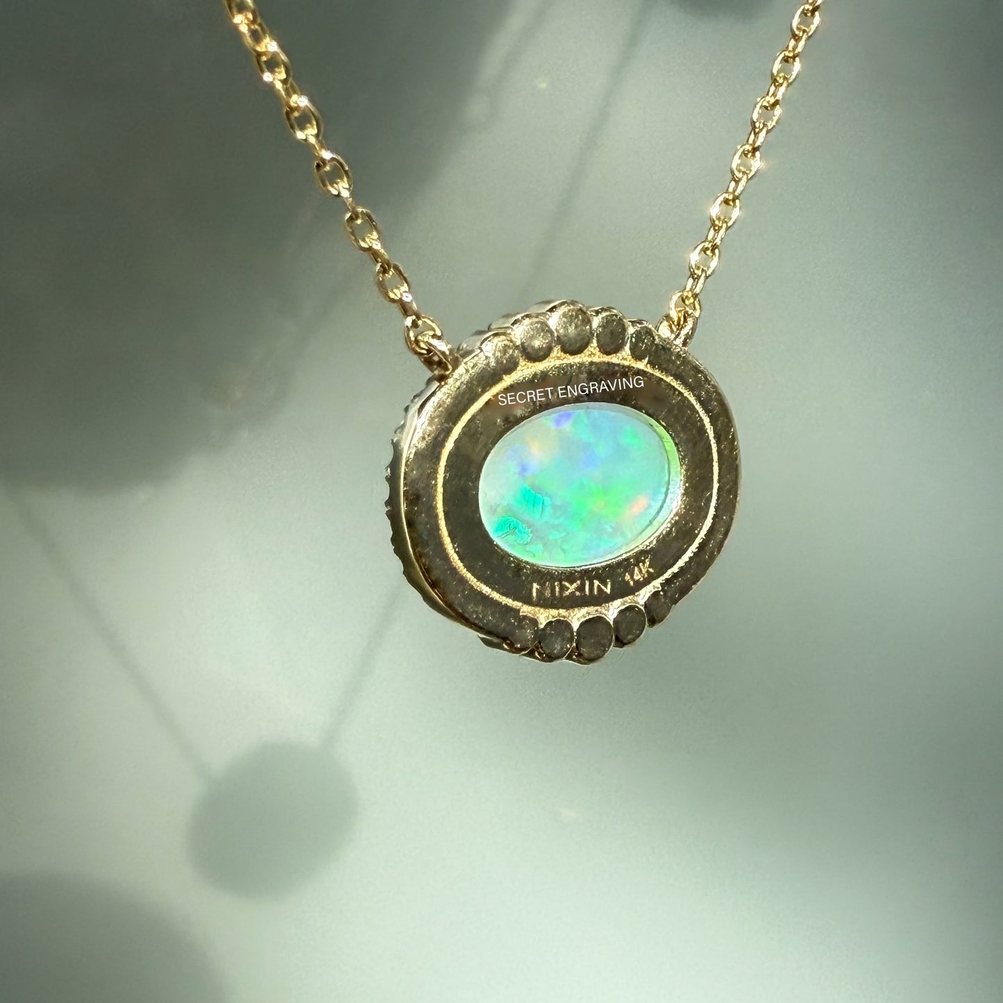 An Australian Opal Necklace by NIXIN Jewelry, showing the back of the 14k gold opal pendant. The reverse reveals the precise metalwork and engraving, certifying its NIXIN quality. This unique jewelry piece is a high-value example of rare jewelry.