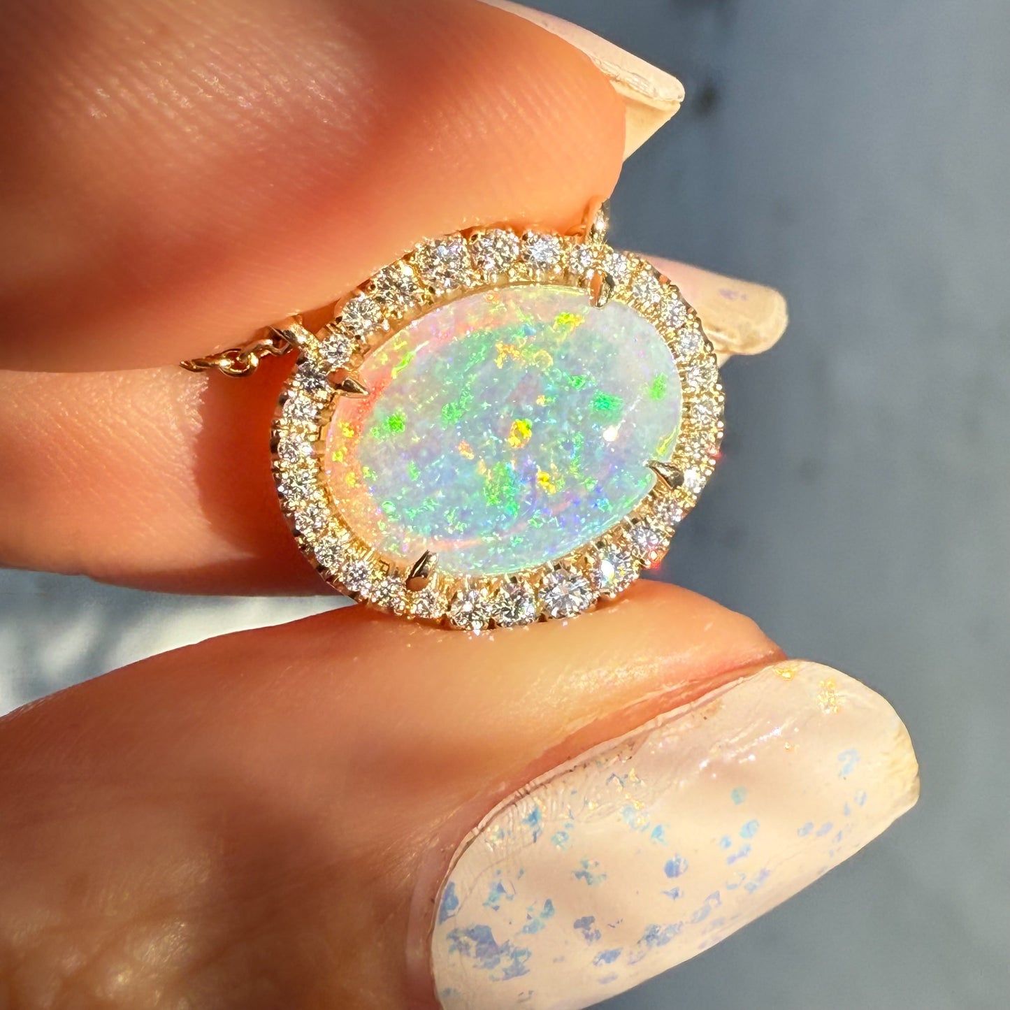 An Australian Opal Necklace by NIXIN Jewelry, emphasizing the bright, full spectrum of light reflection from the crystal opal. This luxury necklace features a diamond halo, demonstrating the striking contrast of opals and diamonds. A truly unique opal necklace for exceptional moments.