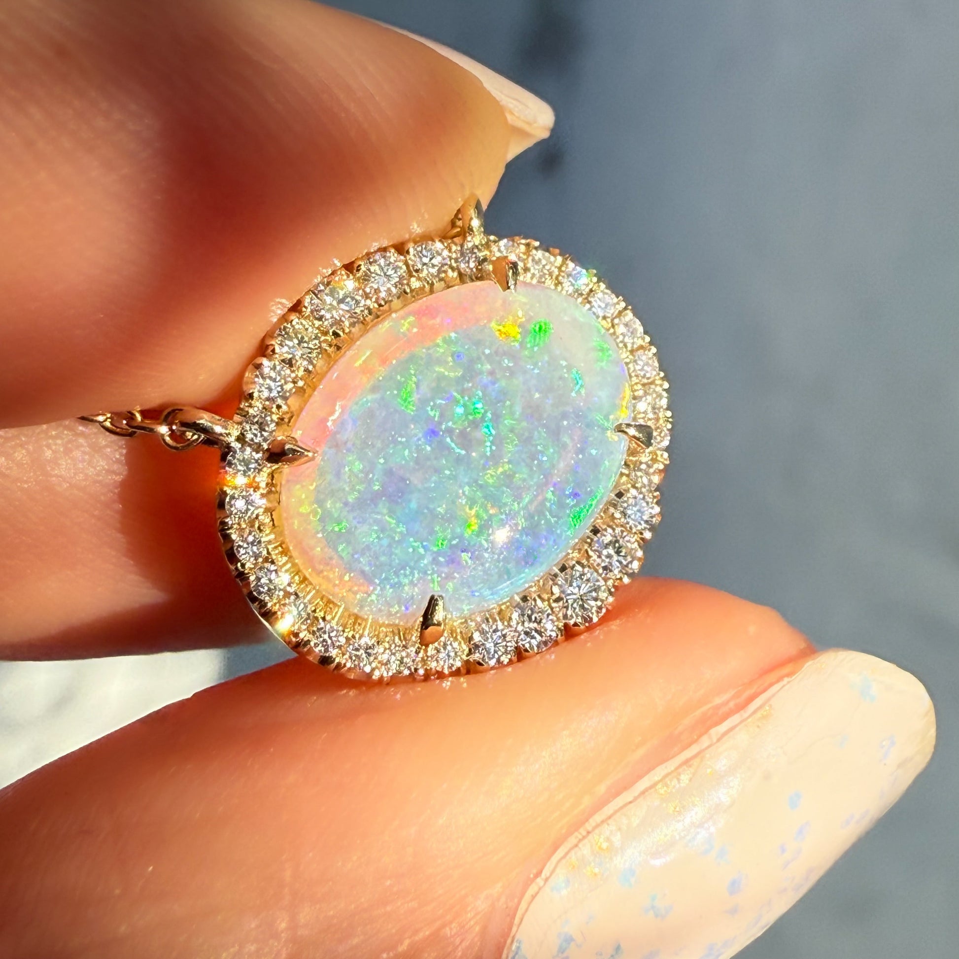 An Australian Opal Necklace by NIXIN Jewelry, showcasing the oval opal held at a slight angle. This natural opal possesses extraordinary color saturation and serves as the heart of this unique opal jewelry. It is an exceptional example of an opal stone used in high-end jewelry art.