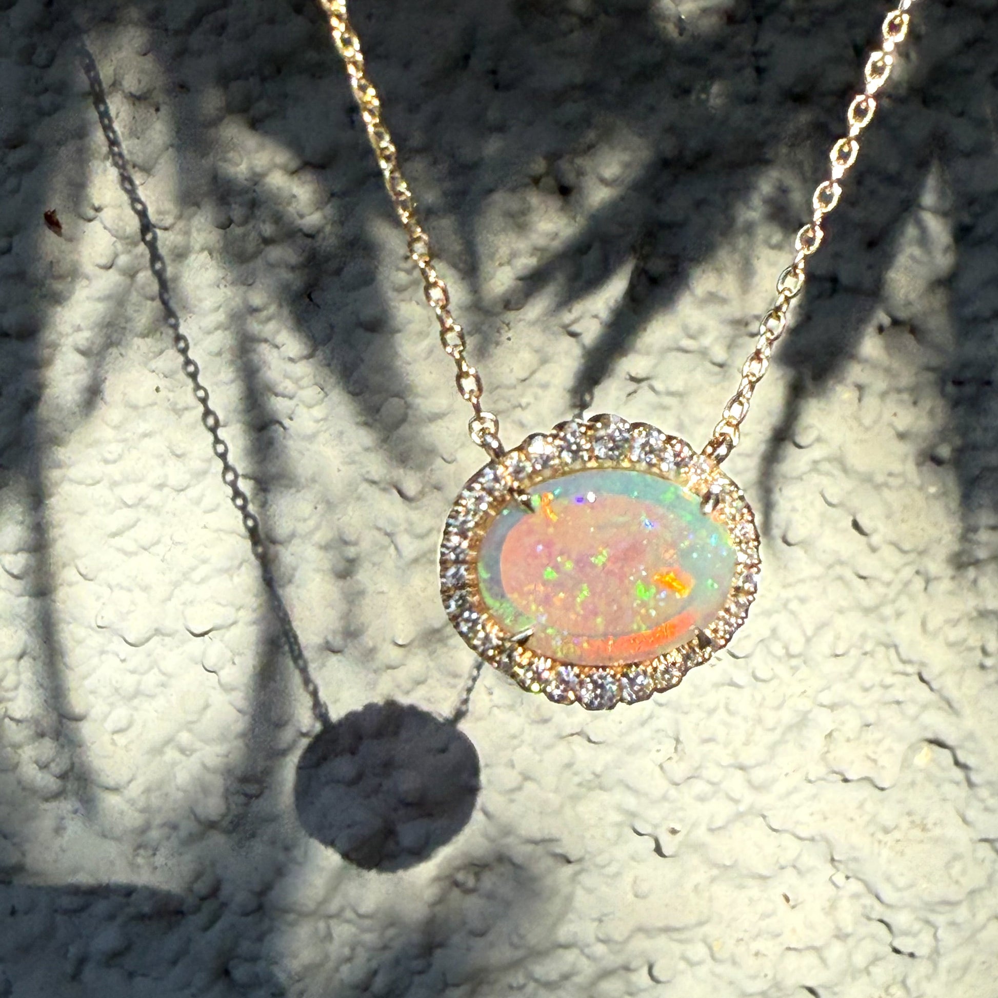 An Australian Opal Necklace by NIXIN Jewelry, featuring a magnificent Lightning Ridge crystal opal in 14k gold. This luxury necklace showcases a dazzling diamond halo and represents unique fine jewelry. A premier example of opal and diamond craftsmanship for women's luxury necklace wear.