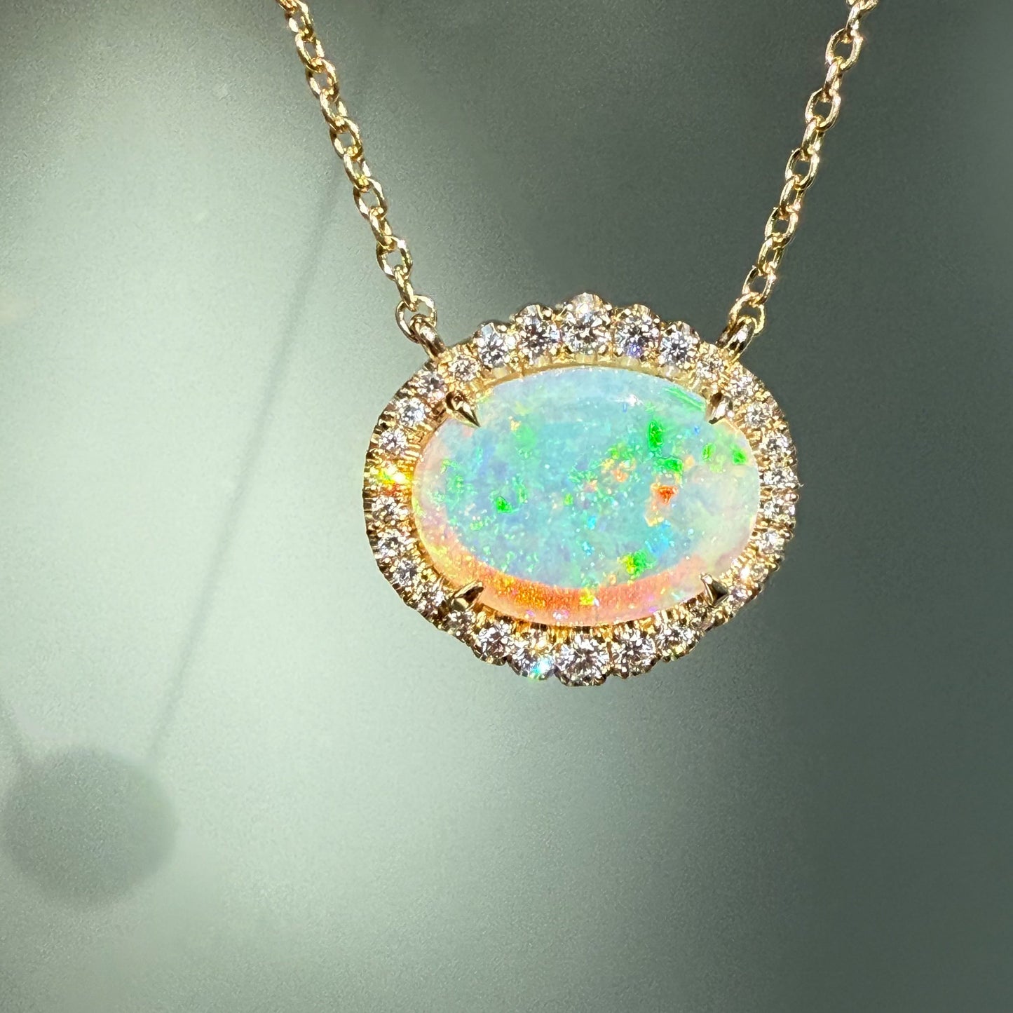 An Australian Opal Necklace by NIXIN Jewelry, showcasing an mesmerizing opal stone with a vibrant color spectrum. This crystal opal necklace, set in a halo of diamonds, offers unparalleled luxury jewelry. Explore this unique opal jewelry, a signature NIXIN piece.