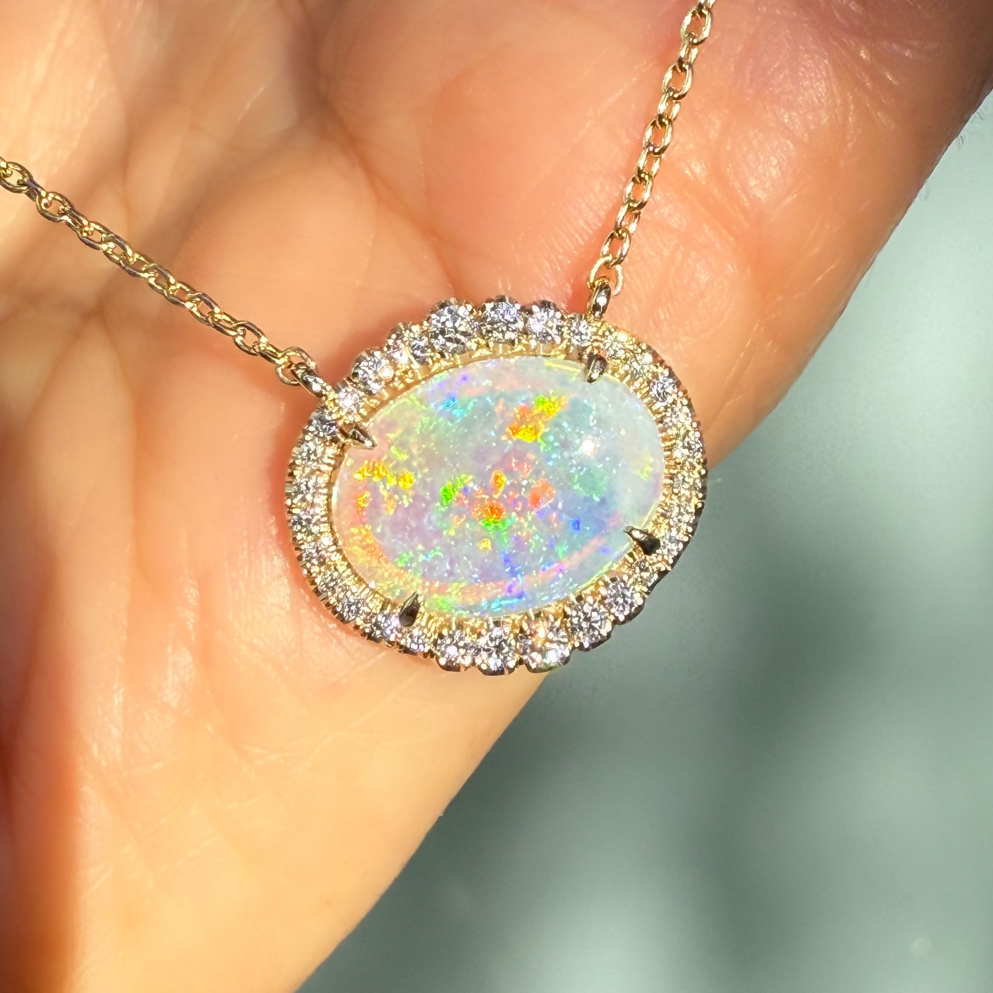 An Australian Opal Necklace by NIXIN Jewelry, featuring a magnificent crystal opal with brilliant flashes of color. The opal pendant is adorned with a pave diamond halo, making it a distinctive opal and diamond piece. This luxury necklace represents unique jewelry at its finest.