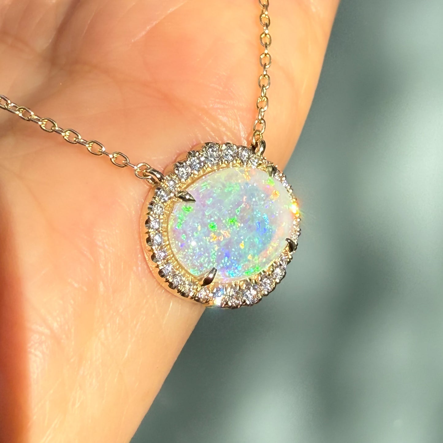 An Australian Opal Necklace by NIXIN Jewelry, showcasing a vibrant crystal opal in a secure prong setting. This unique opal necklace, framed by pave diamonds, embodies luxury jewelry. Discover the allure of this gold opal necklace, a true piece of jewelry art.