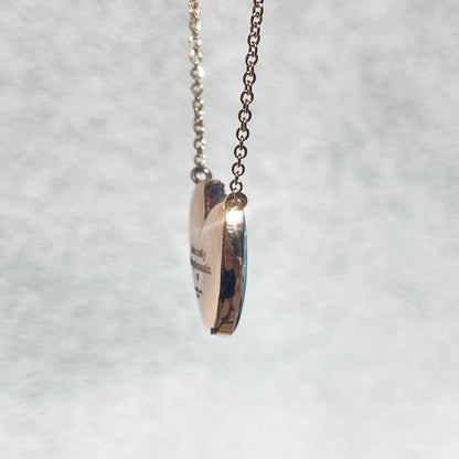 Side view of a Heart Opal Necklace by NIXIN Jewelry showing a glimpse of the secret engraving on the back.