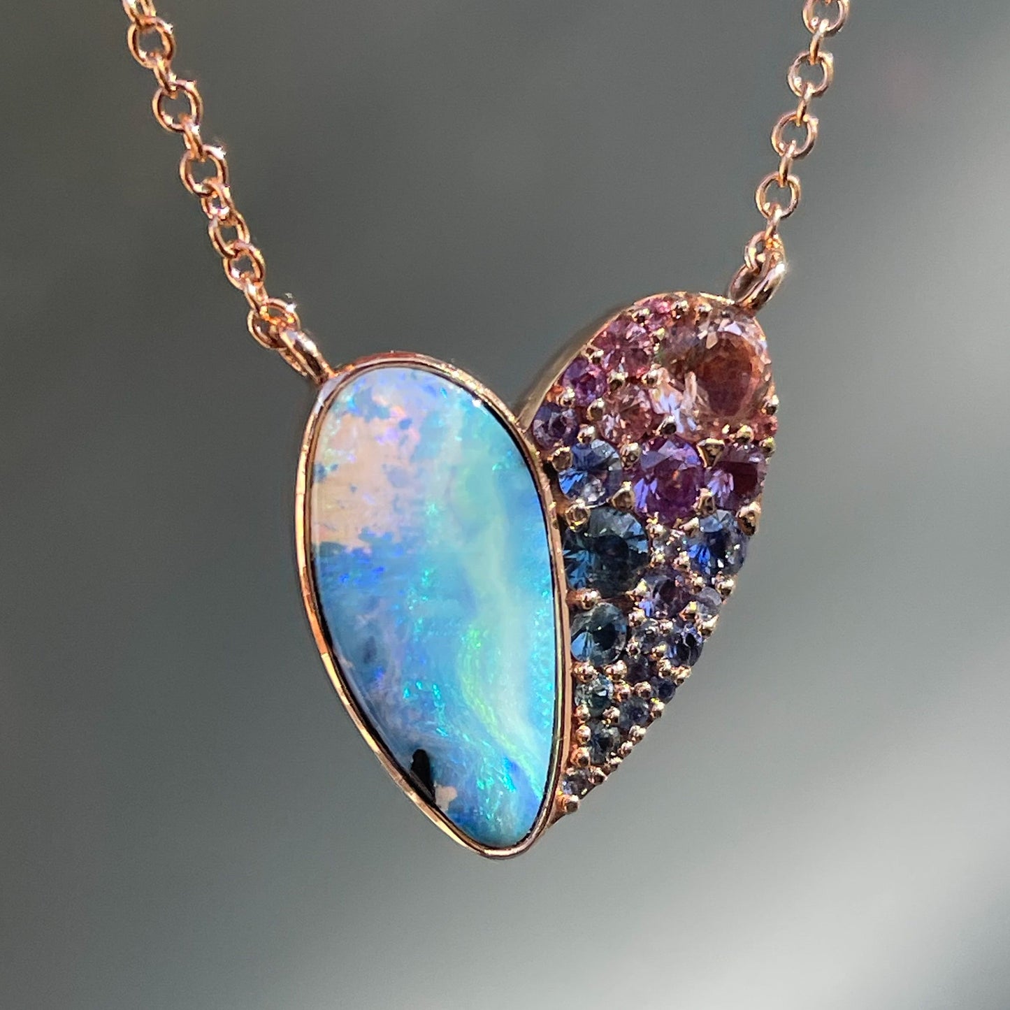 A Heart Opal Necklace by NIXIN Jewelry with a blue opal and multicolored sapphires in 14k rose gold.