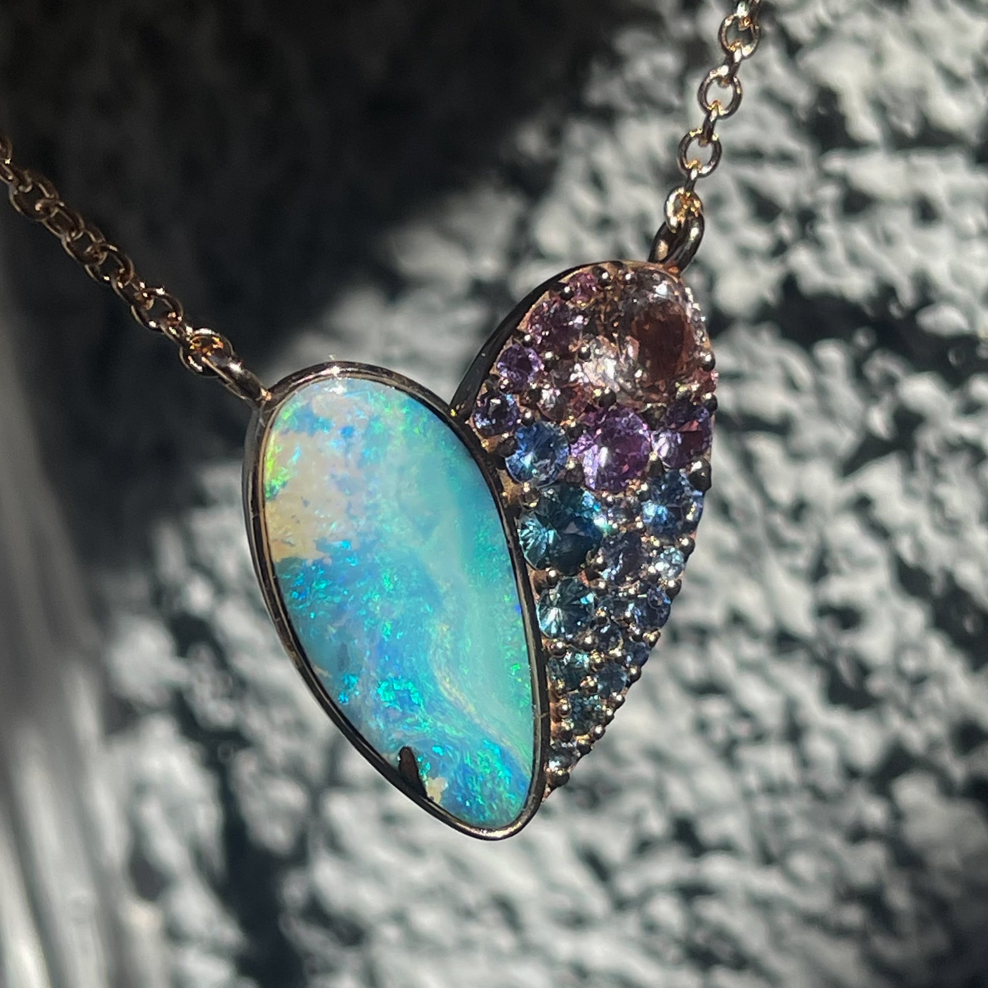 A Heart Opal Necklace by NIXIN Jewelry with a Boulder Opal and sapphires set in rose gold.