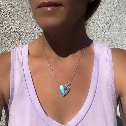 Model wearing a Heart Opal Necklace by NIXIN Jewelry with a Boulder Opal and sapphires.