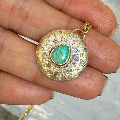 An Australian Opal Necklace by NIXIN Jewelry presents a contemporary opal pendant. In shade, its bezel set crystal opal appears predominantly green, yet flashes a full spectrum of color when in shifting light.