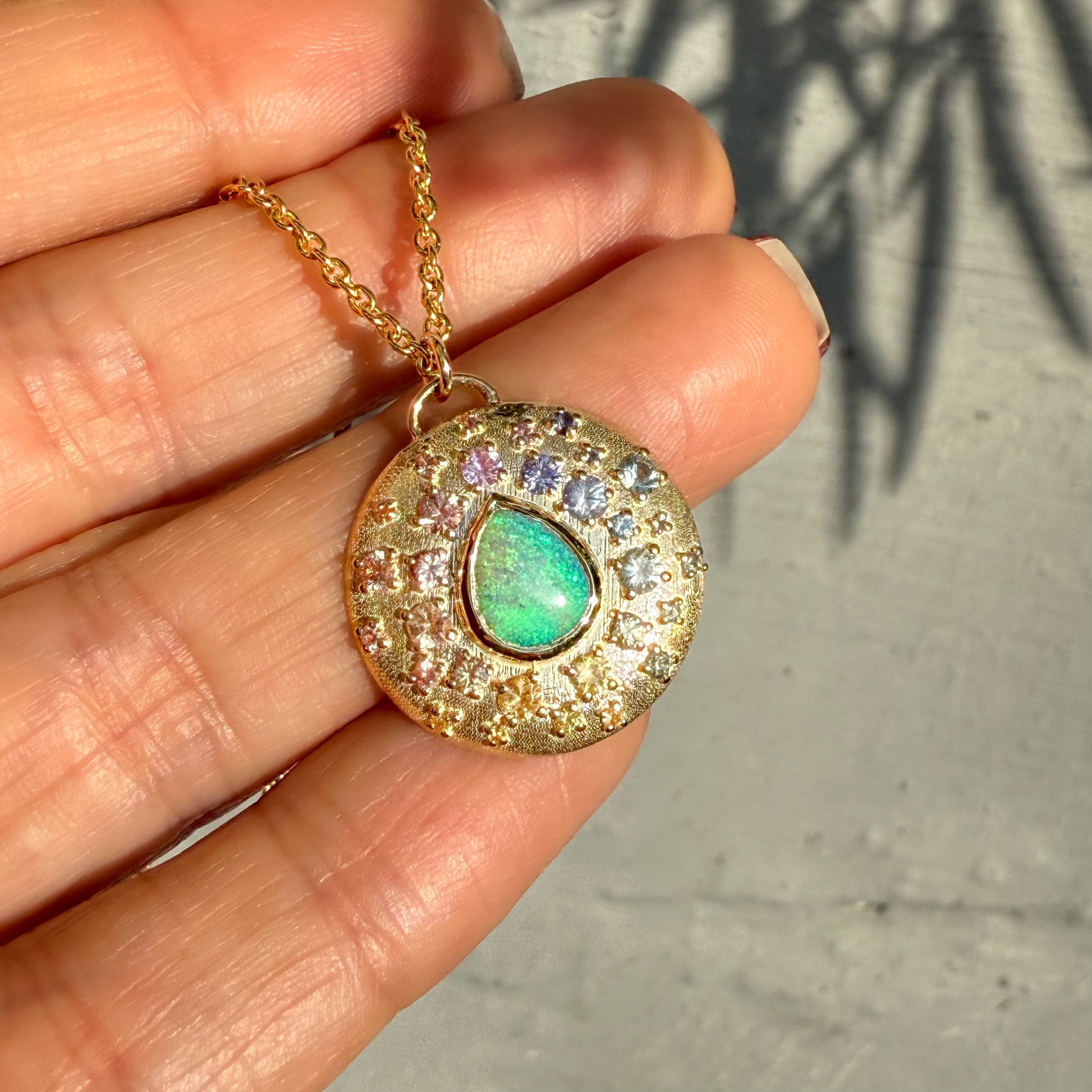 An Australian Opal Necklace by NIXIN Jewelry includes a captivating green crystal opal that flashes blue hues. This rare jewelry piece radiates vibrant color and intricate detail.