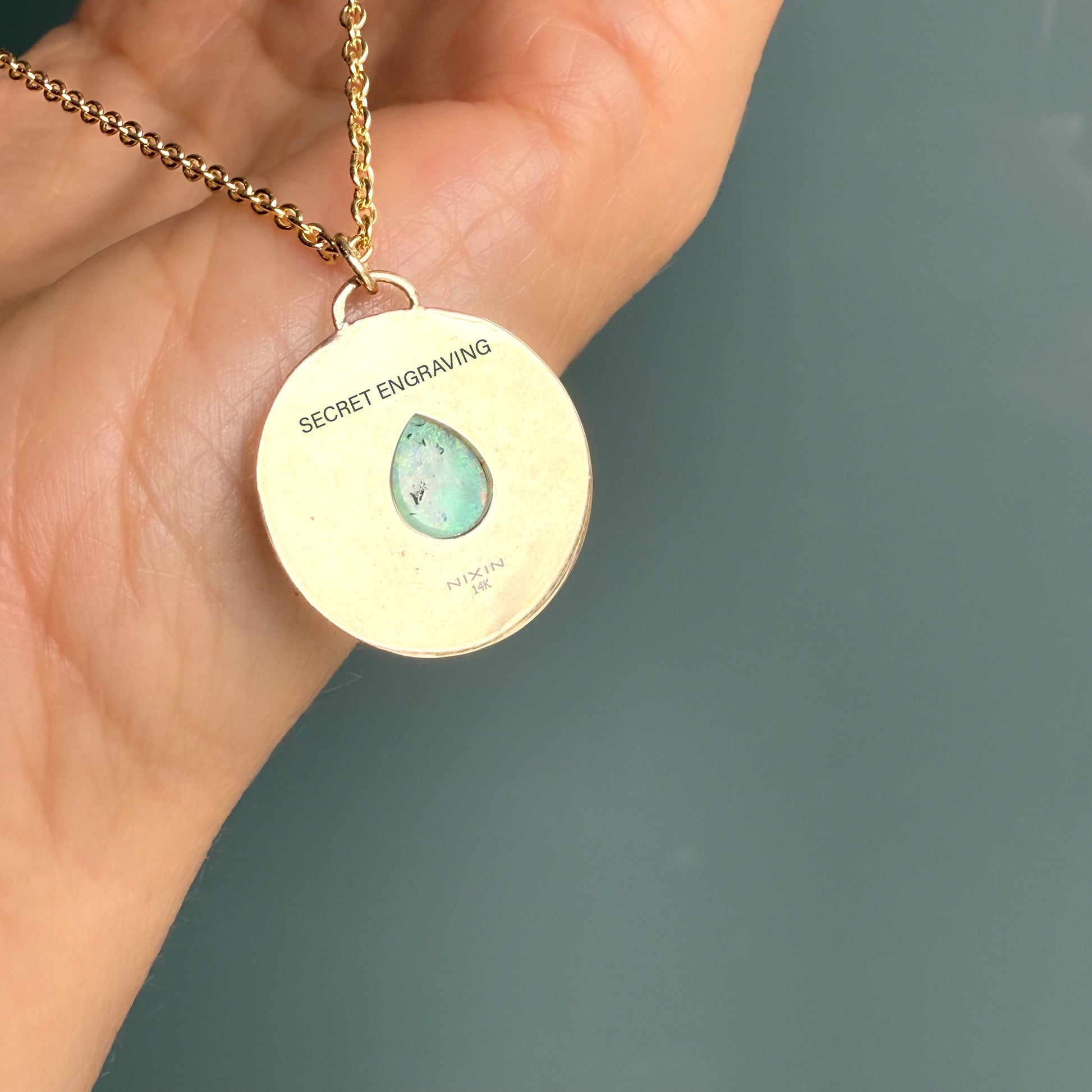 Back side of an Australian Opal Necklace by NIXIN Jewelry - a beautiful example of australian opal jewelry. This gold opal necklace highlights a textured gold disc adorned with a spray of precious gemstones.
