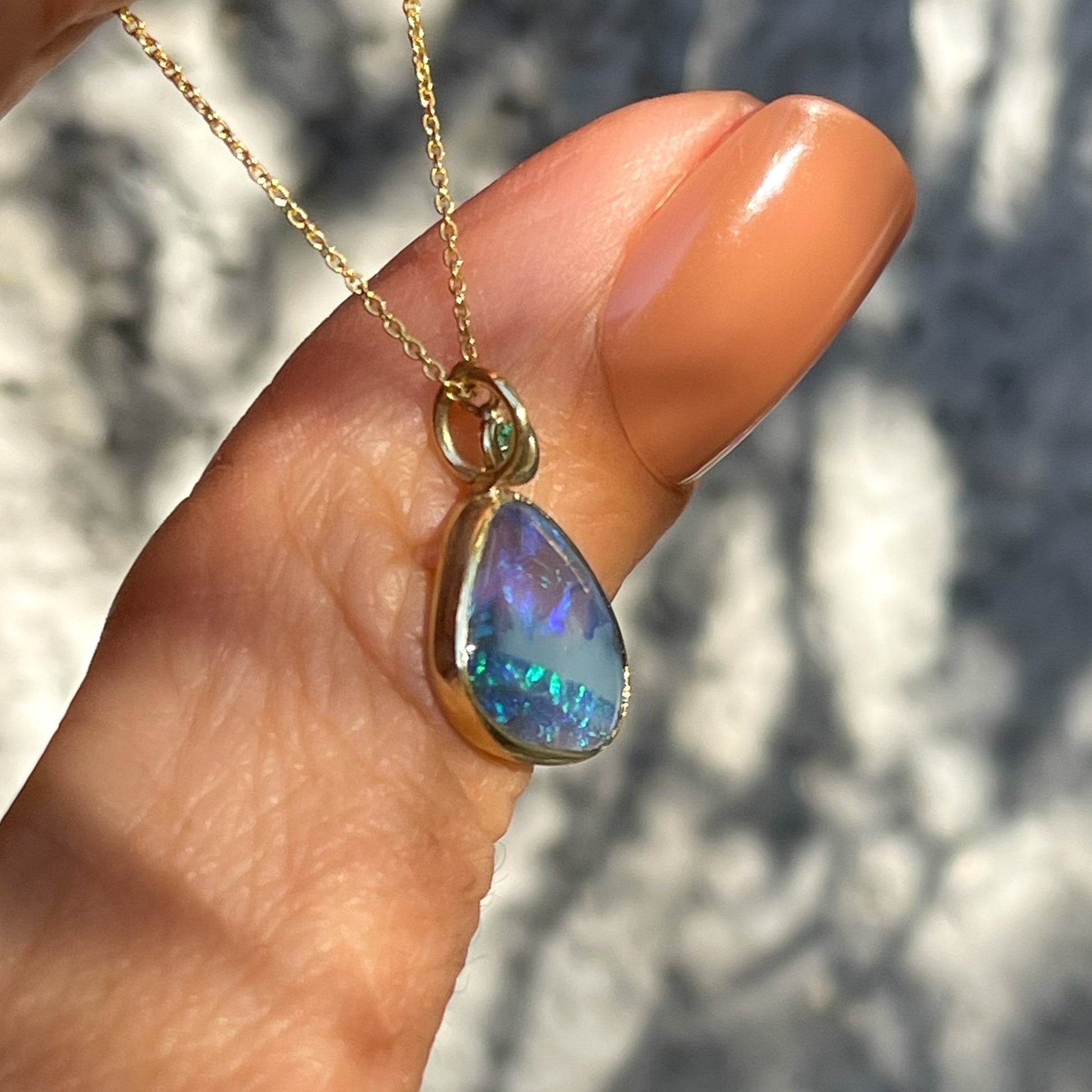 Side view of an Australian Opal Necklace by NIXIN Jewelry. Photo shows the bezel setting of the opal pendant in profile.
