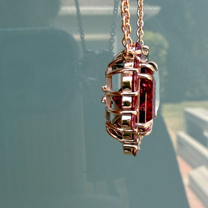 Side profile of the Empress Imbued Tourmaline Necklace by NIXIN Jewelry exposing the handcrafted rose gold gallery basket beneath the gemstone halo.