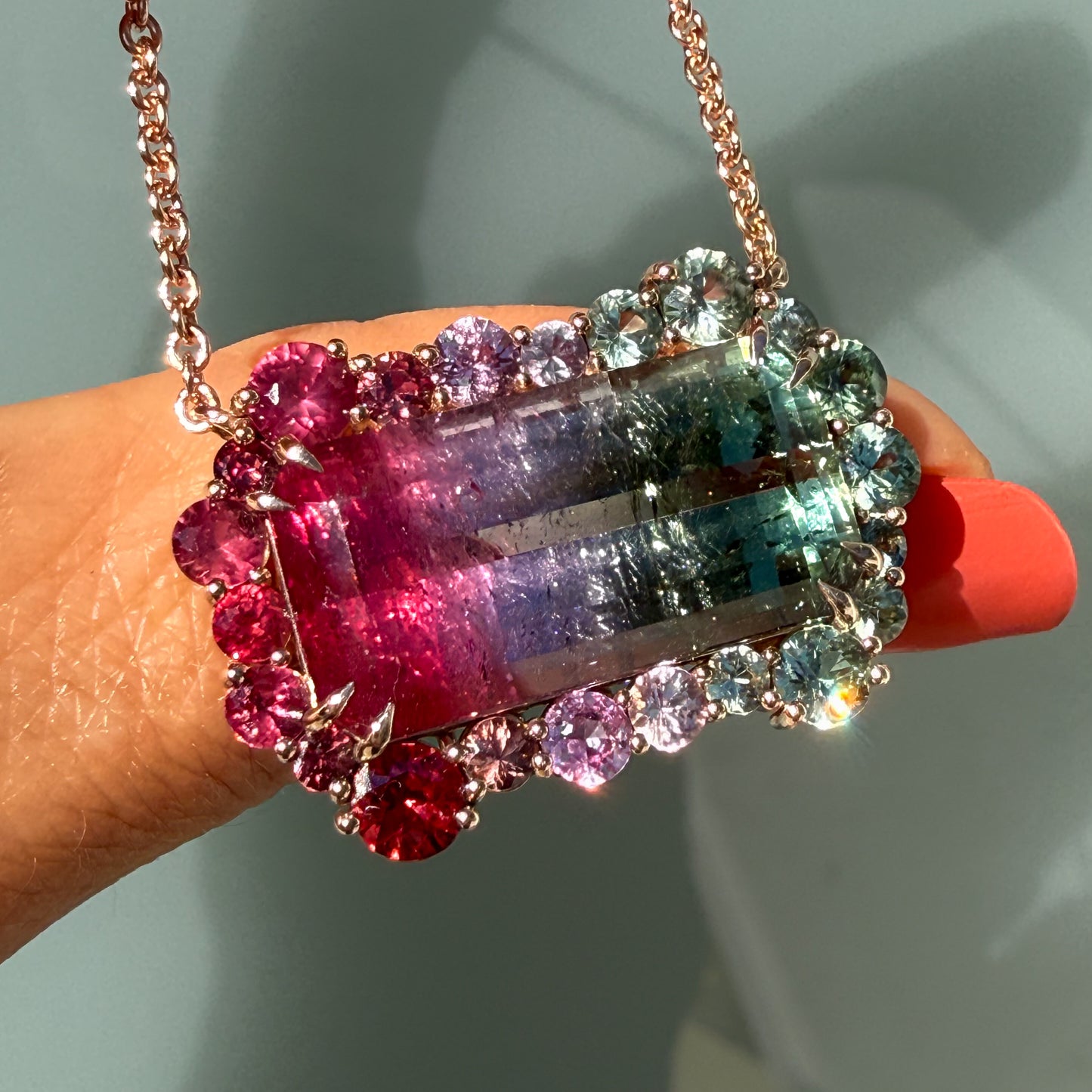 Empress Imbued Tourmaline Necklace by NIXIN Jewelry draped across a fingertip to show true-to-life scale of the one-of-a-kind pendant.