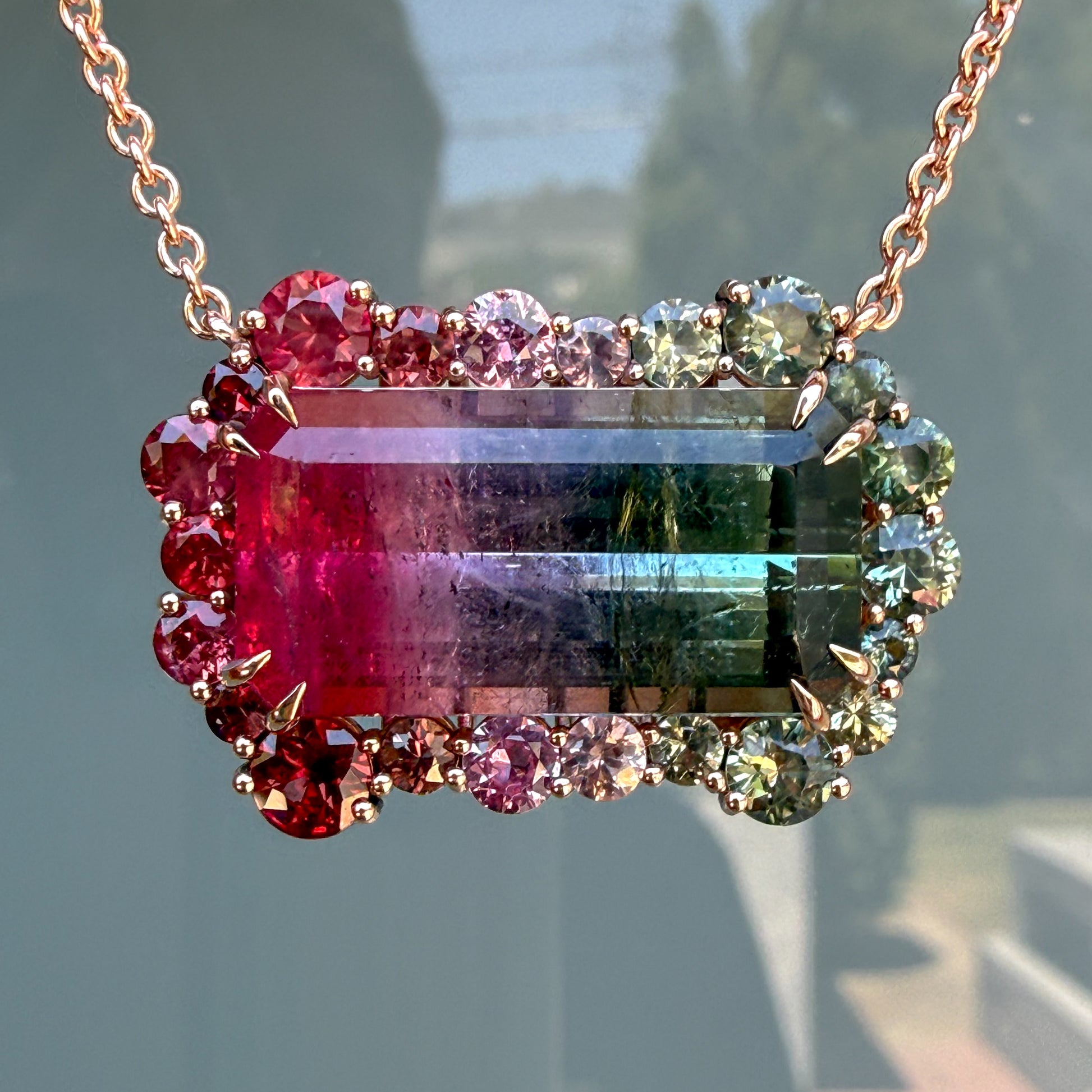 Front-facing detail of the Empress Imbued Tourmaline Necklace by NIXIN Jewelry against a shadow-dappled backdrop, showing the tourmaline's natural color zoning.