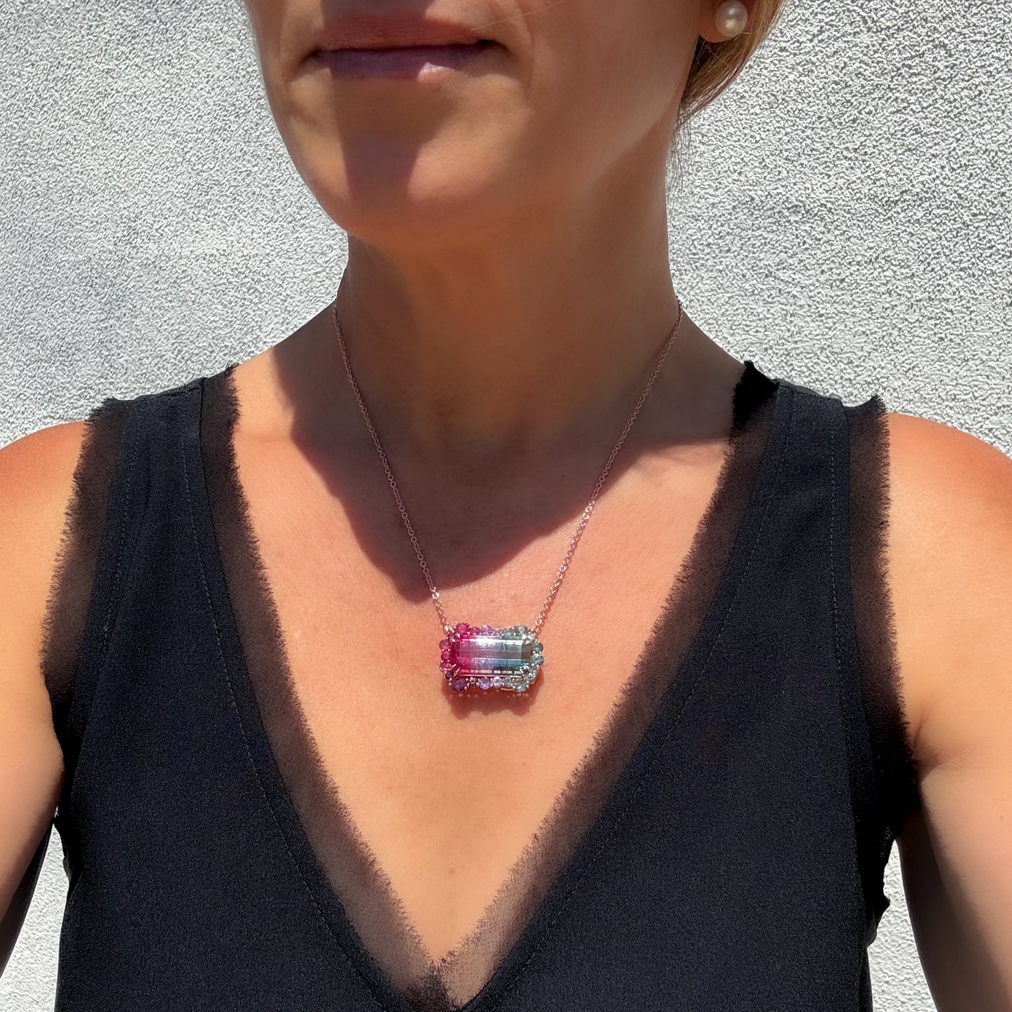 NIXIN Jewelry Empress Imbued Tourmaline Necklace worn at the décolletage, showing the bi-color tourmaline pendant and rose gold chain in natural sunlight.