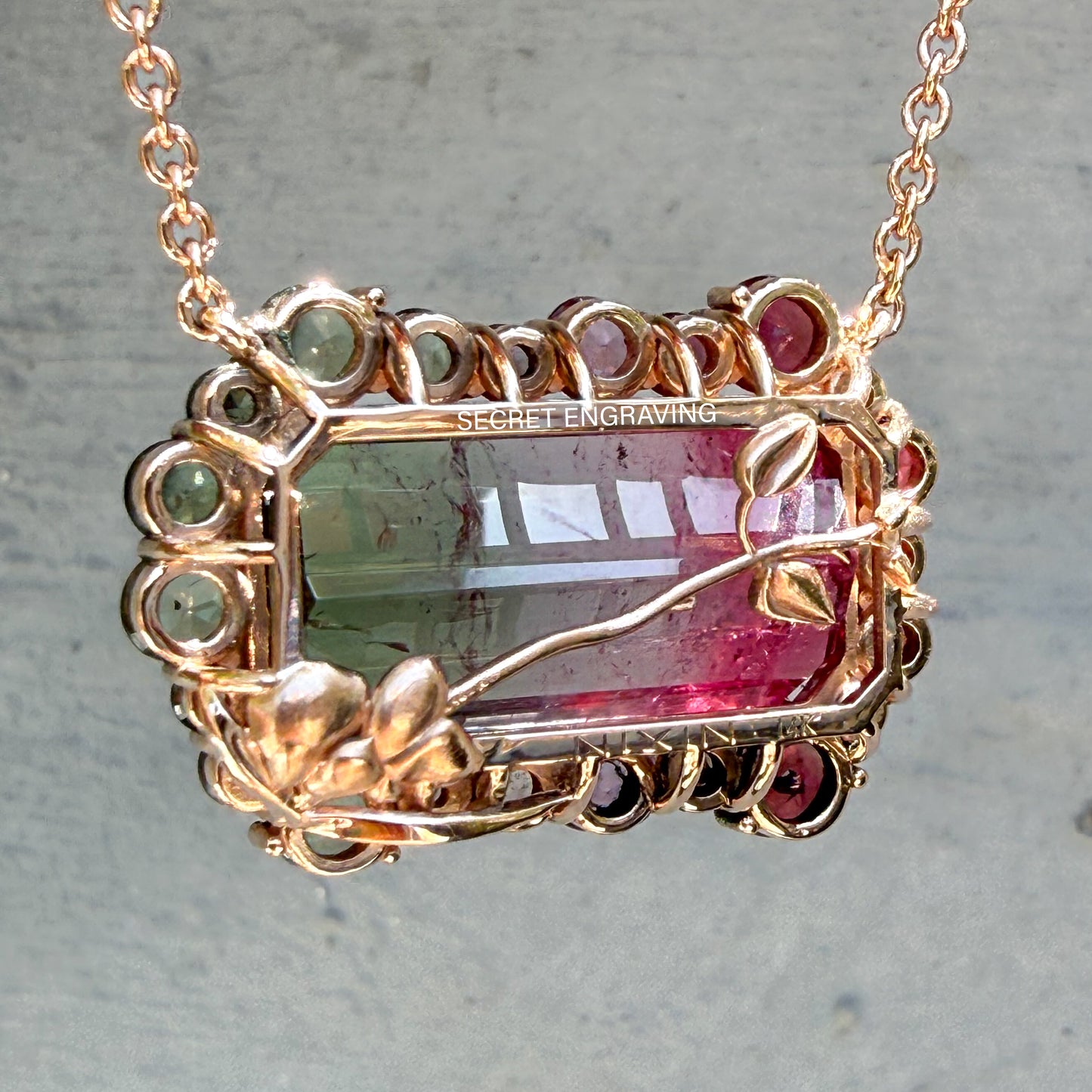 Reverse view of the Empress Imbued Tourmaline Necklace by NIXIN Jewelry revealing the secret engraving and NIXIN 14K gold hallmark with hand-finished orchid flower detailing.