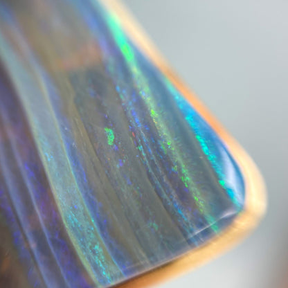 A close up shot of the bezeled corner of an Australian Opal Necklace by NIXIN Jewelry.