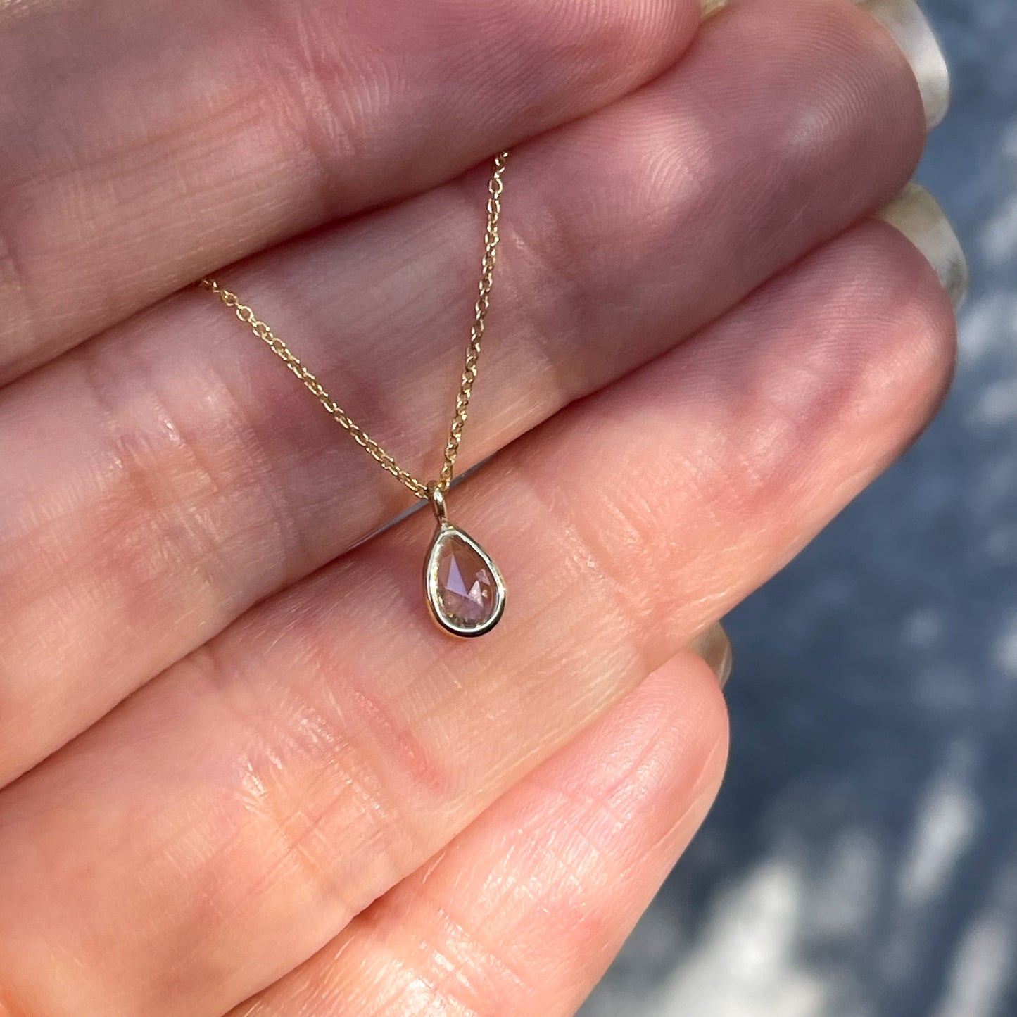 A Dainty Diamond Necklace by NIXIN Jewelry with a diamond charm on a delicate gold chain.