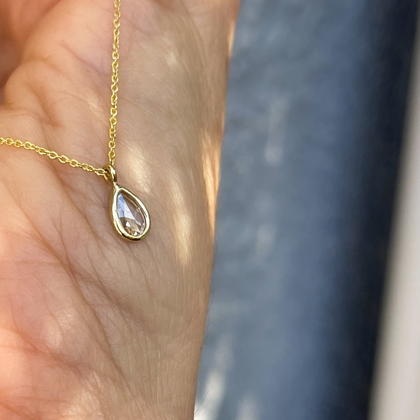 Angled view of a Dainty Diamond Necklace by NIXIN Jewelry made as a pendant with a bezel setting.