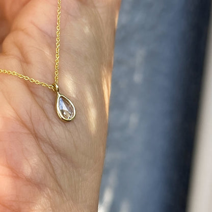 Angled view of a Dainty Diamond Necklace by NIXIN Jewelry made as a pendant with a bezel setting.