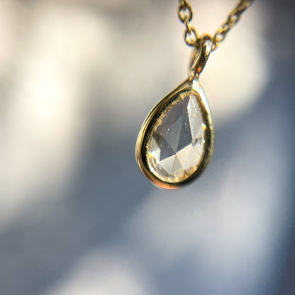 Close up of a Dainty Diamond Necklace by NIXIN Jewelry showing the rose cut diamond set in yellow gold.