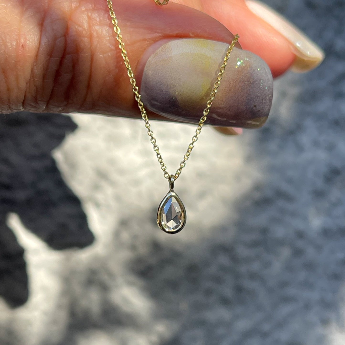 A Dainty Diamond Necklace by NIXIN Jewelry. A gold diamond pendant on a thin chain.