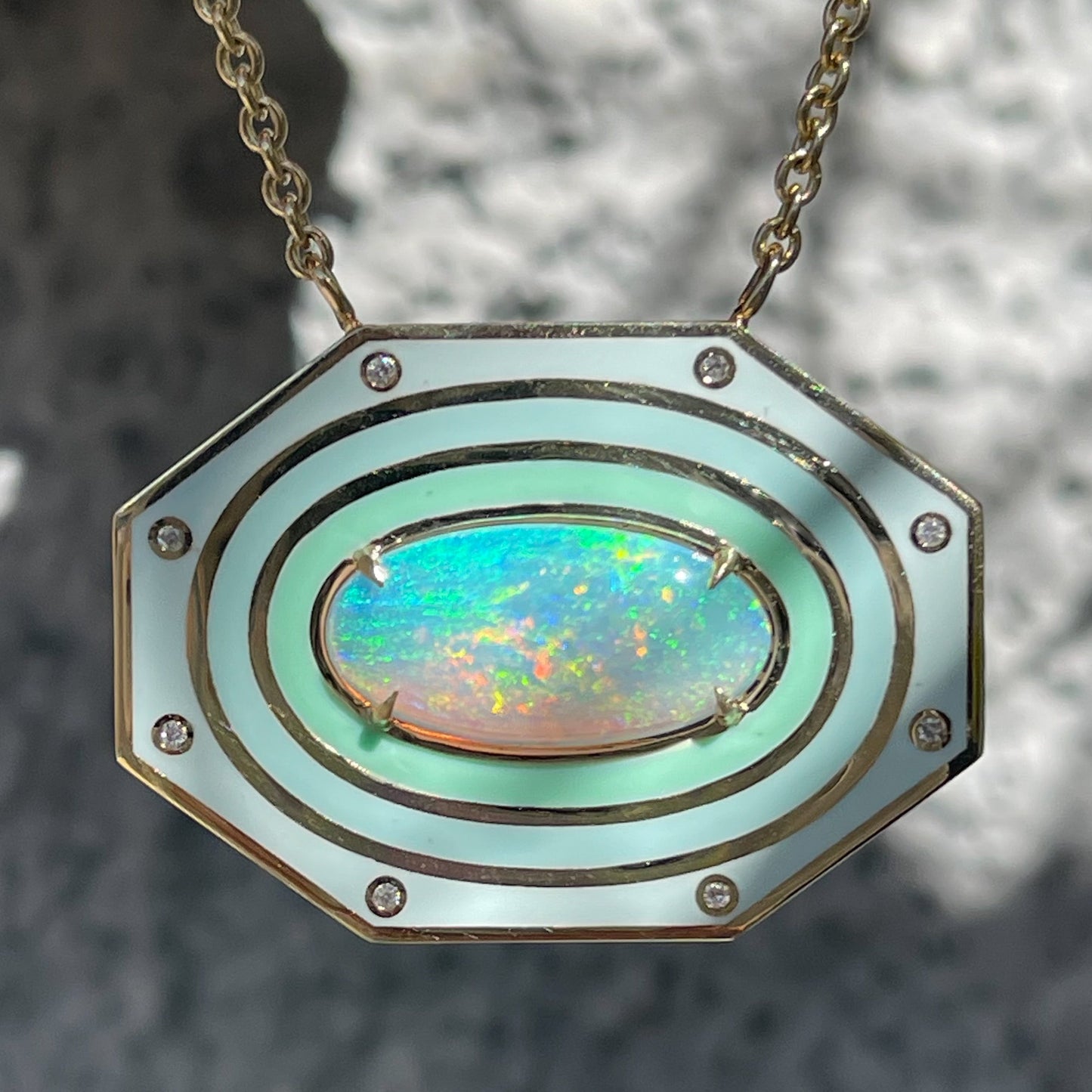 An Australian Opal Necklace by NIXIN Jewelry. The gold opal necklace has a crystal opal and enamel halo.