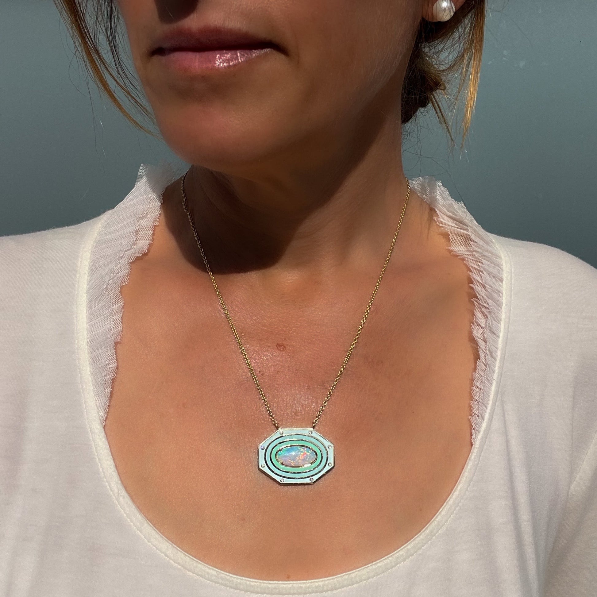 Model wearing an Australian Opal Necklace by NIXIN Jewelry. Rare opal jewelry with enamel, diamonds and gold.