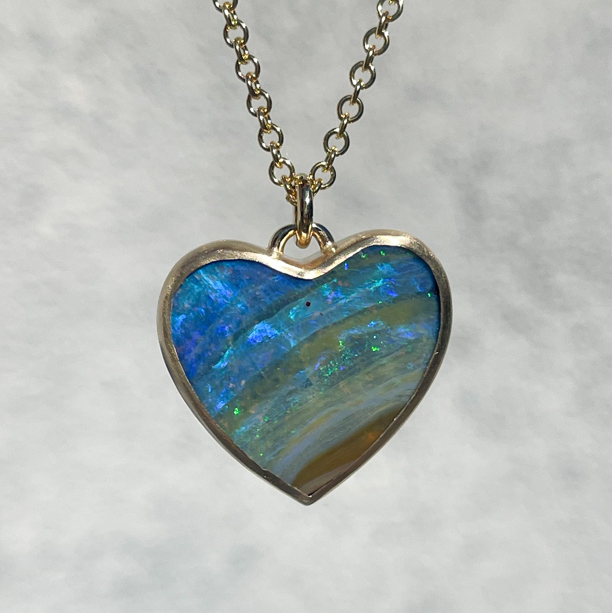 An Australian Opal Necklace by NIXIN Jewelry with a natural opal stone set in yellow gold.