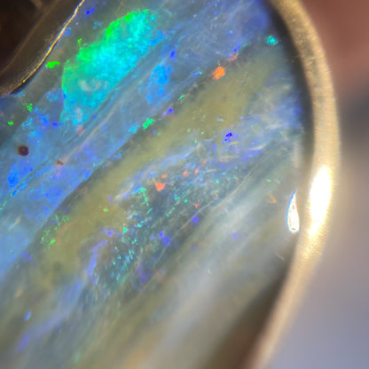 Close up of an Australian Opal Necklace by NIXIN Jewelry showing the Boulder Opal colors in the gold bezel setting.