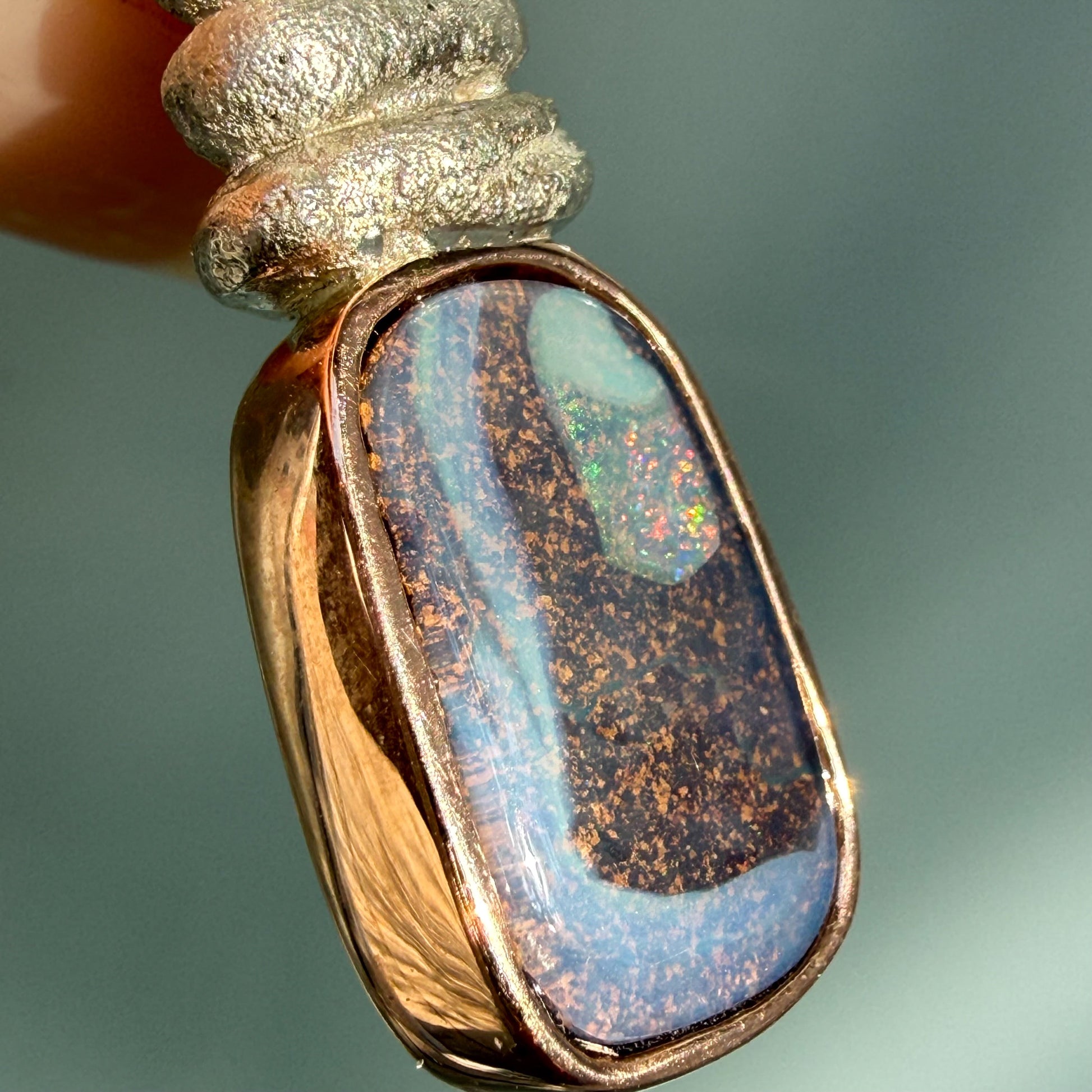 A detailed macro angle of an Australian Opal Necklace by NIXIN Jewelry captures the intricate "picture stone" qualities of the gemstone. This rare opal necklace displays a landscape-like pattern that is exclusive to Australian opal jewelry. It is an ideal luxury necklace for collectors who appreciate the rarity of opals.