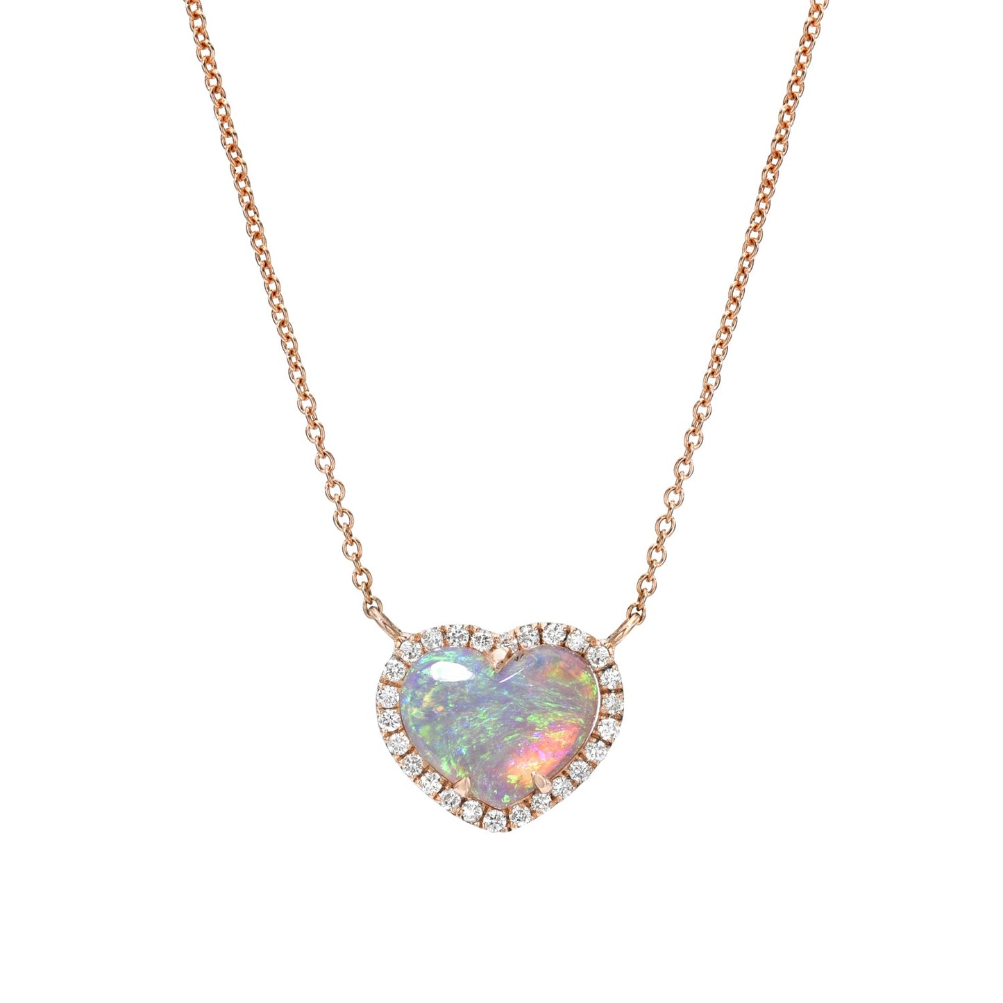 An Opal Heart Necklace by NIXIN Jewelry hanging in front of a white backdrop. The necklace is made with a Crystal Opal and diamonds in 14k rose gold.