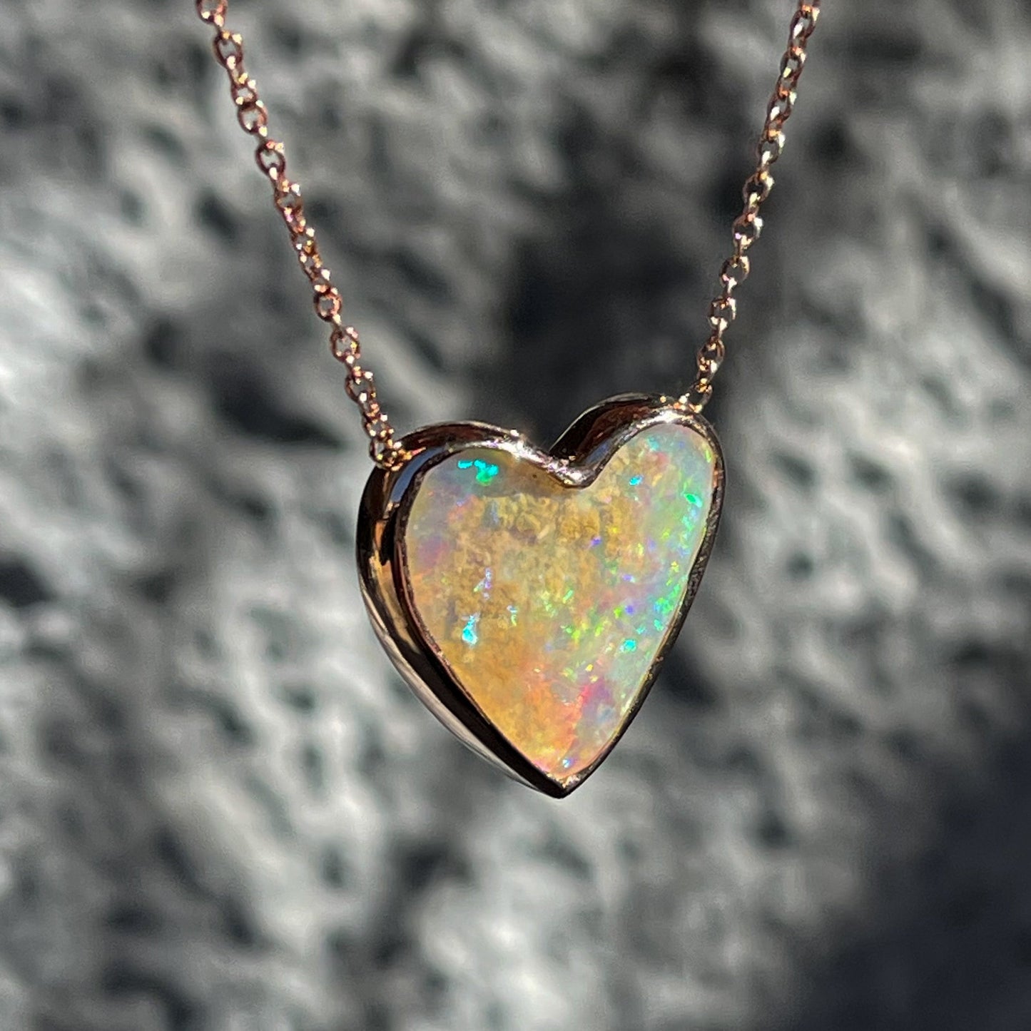 Side view of an Australian Opal Necklace by NIXIN Jewelry set in 14k rose gold.
