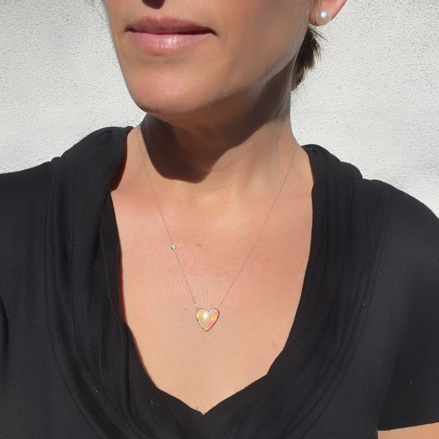Model wearing an Australian Opal Necklace by NIXIN Jewelry with a diamond in the rose gold chain.