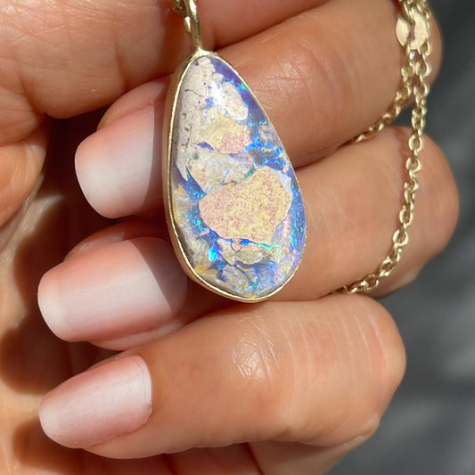 An Australian Opal Necklace by NIXIN Jewelry, designed with a bezel setting that secures a Lightning Ridge Opal  with natural sandstone patterns. This women's luxury necklace blends opal pendant elegance with contemporary design.