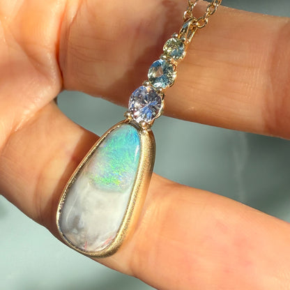 An Australian Opal Necklace by NIXIN Jewelry where the natural opal flashes brilliant greens and blues, secured in a substantial bezel setting. This piece is the epitome of jewelry art, offering true unique fine jewelry value.