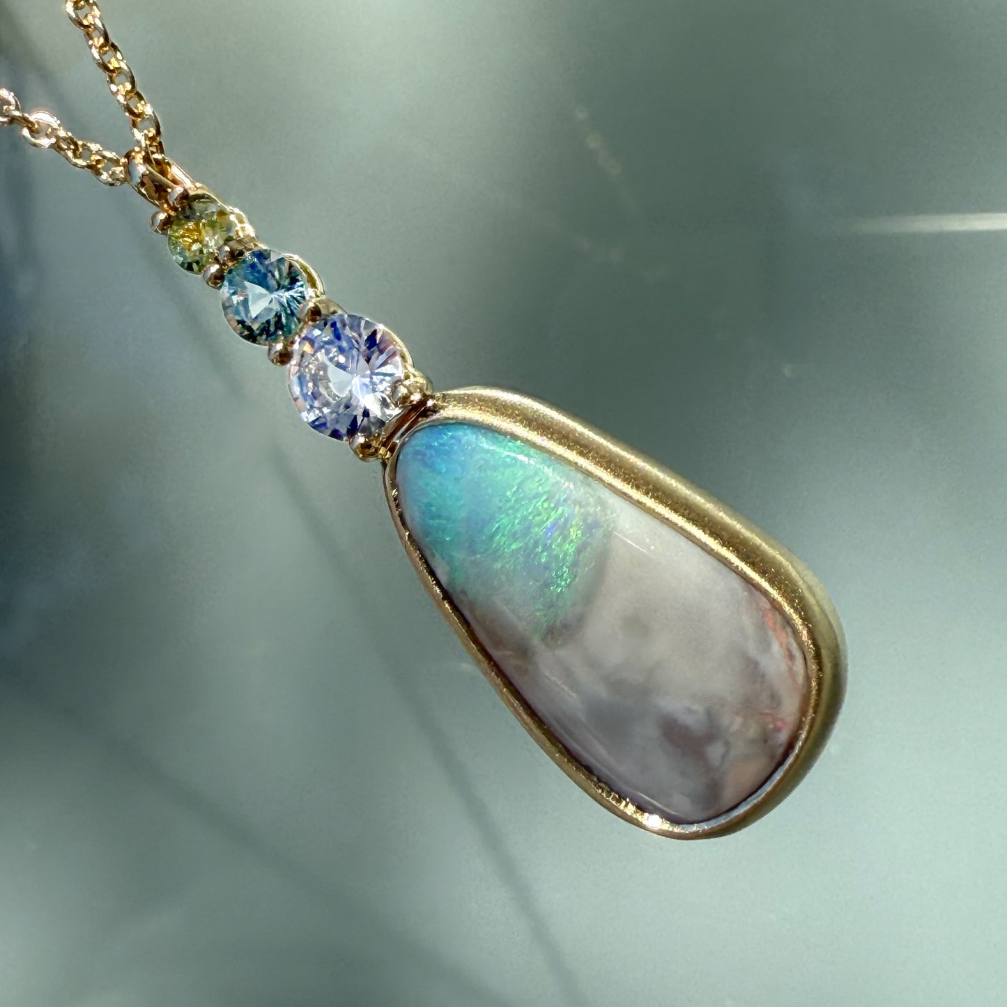 An Australian Opal Necklace by NIXIN Jewelry designed with precision and showcasing an iridescent blue opal centerpiece. This specialized design highlights the unique jewelry nature of NIXIN's rare opal necklace offerings and special use of color.