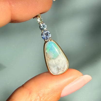 An Australian Opal Pendant by NIXIN Jewelry displaying a rare opal necklace featuring exceptional color play from the Grawin fields. The beautiful body tone and secure bezel setting highlight this luxury necklace.