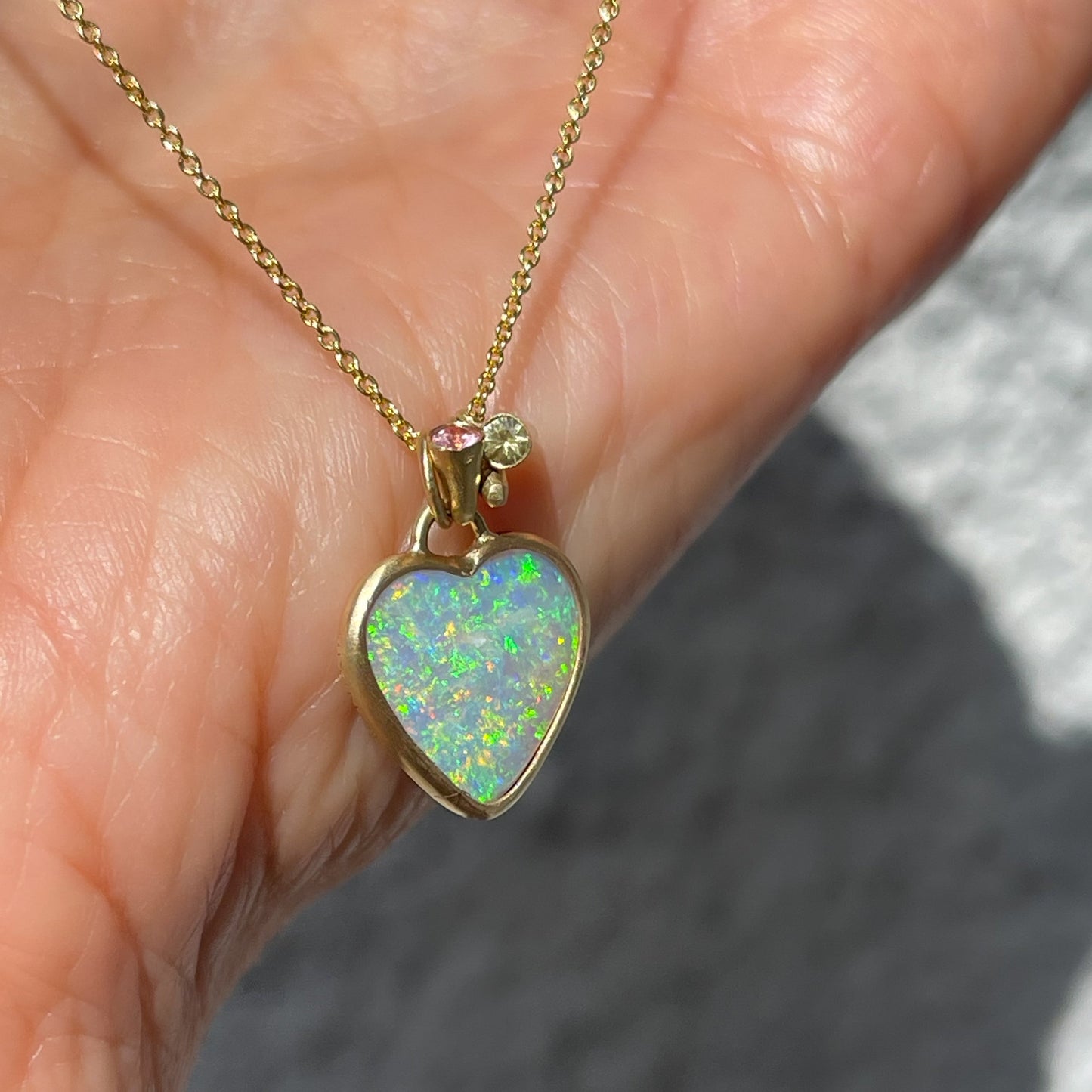 An Australian Opal Necklace by NIXIN Jewelry. The opal heart pendant is double sided and set in yellow gold.