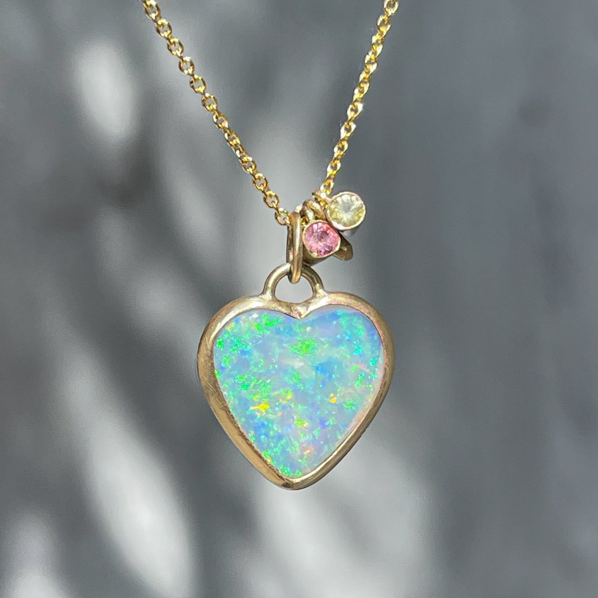 An Australian Opal Necklace by NIXIN Jewelry with an opal heart in a gold bezel setting with matte finish.