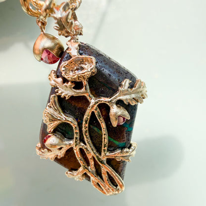 An Australian Opal Necklace by NIXIN Jewelry features a macro view of the 14k gold poppy blooms, with three natural red rubies acting as the shimmering heart of the flowers. The matte finish of the gold provides a sophisticated contrast to the electric green veining within the Australian opal. This rare jewelry piece is an investment in unique fine jewelry that captures the essence of life and hope.