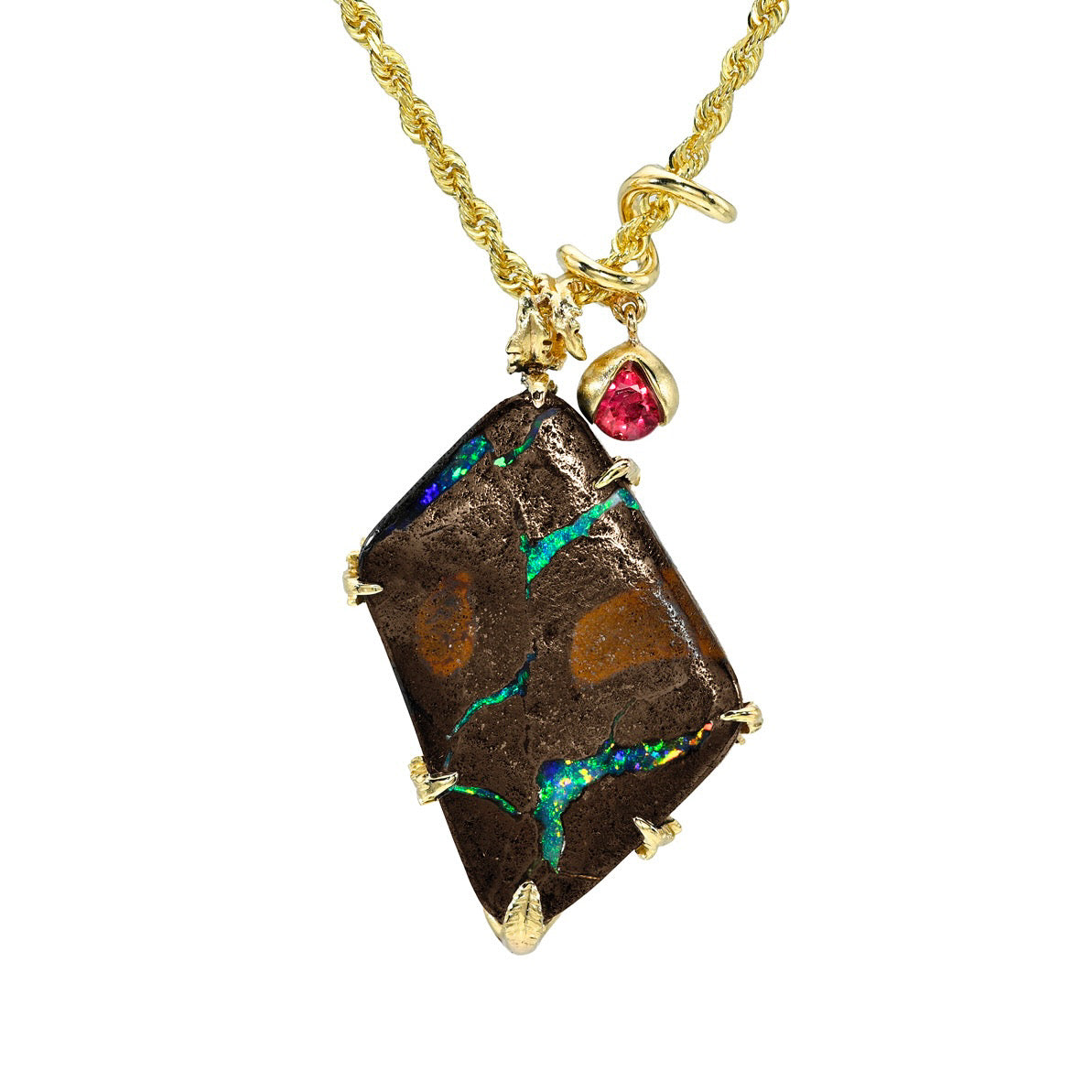 An Australian Opal Necklace by NIXIN Jewelry displays the natural, rugged beauty of a boulder opal secured by a prong setting. This rare jewelry highlights a  crimson ruby charm and a 14k gold bypass bail that gracefully spirals upon itself. It is an elegant opal necklace designed for those seeking unique fine jewelry with a sophisticated matte finish.