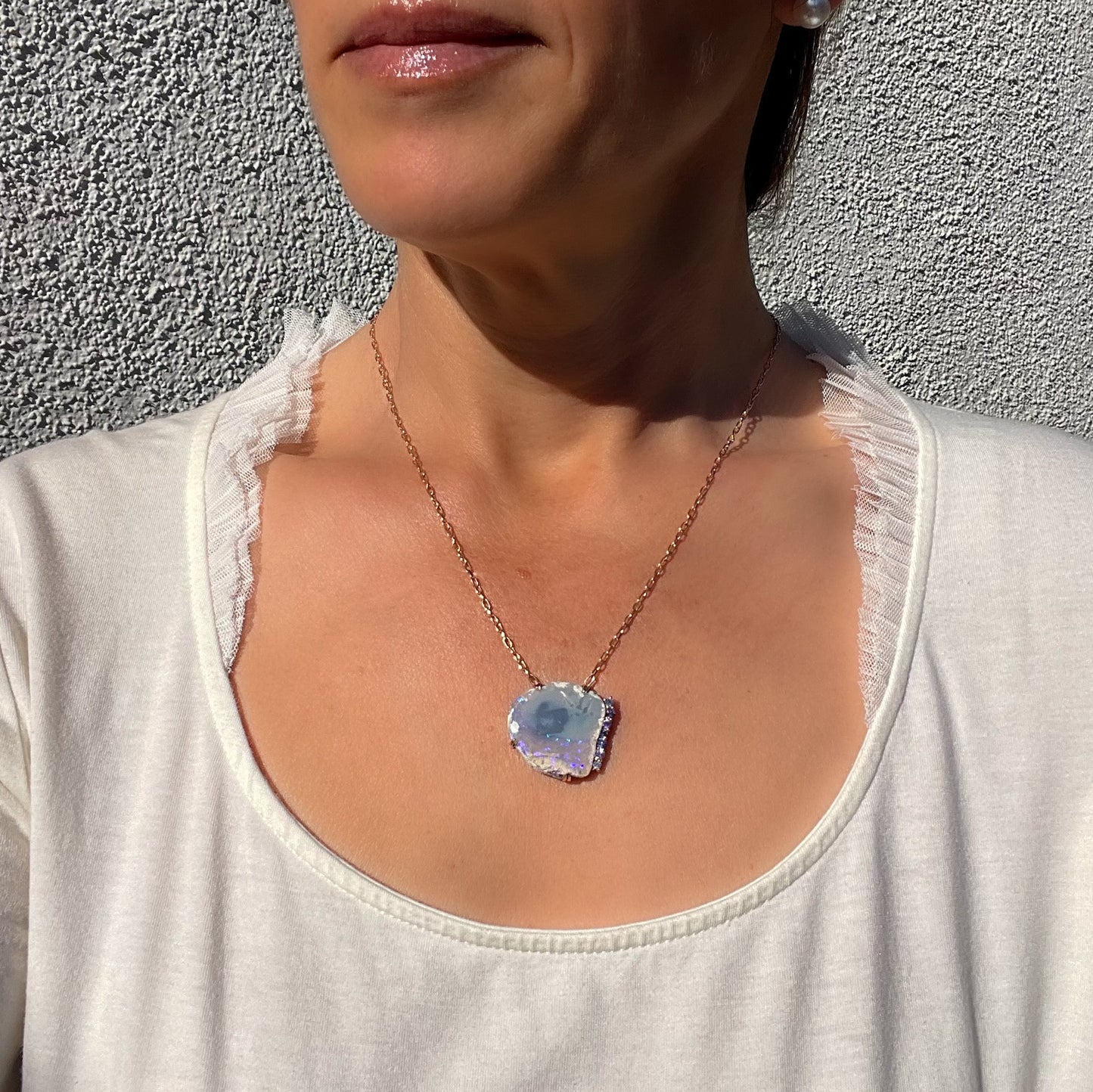 Model wearing an Australian Opal Necklace by NIXIN Jewelry. The opal necklace is made in rose gold. 