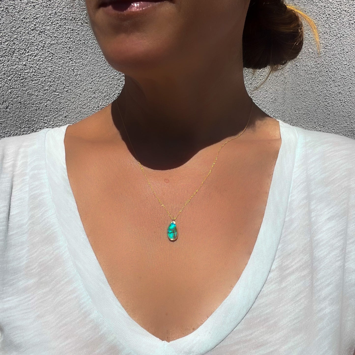An Australian Opal Necklace by NIXIN Jewelry worn by a model to show scale. The opal pendant is locally made and is among the handcrafted jewelry we offer at NIXIN.